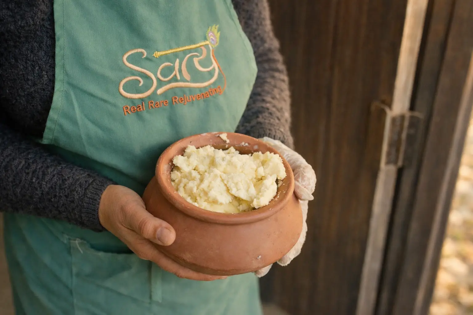 lady with a matka and in matka there is freshly prepared white butter